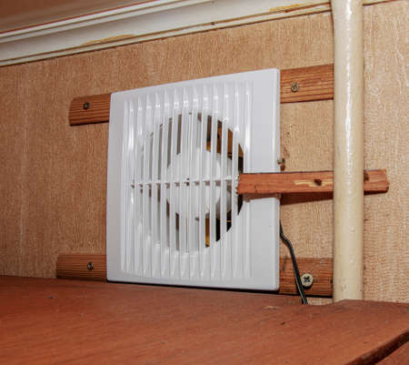 The kitchen exhaust fan after cleaning and washing is installed on the workplace.