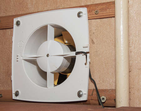 The kitchen exhaust fan after cleaning and washing is installed on the workplace.