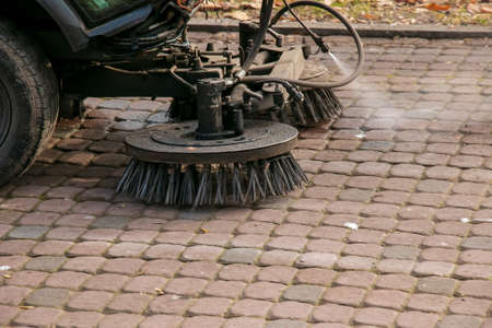 The municipal service conducts seasonal work in the park. The sweeper picks up a lot of debris. The brushes sweep the asphalt.の写真素材