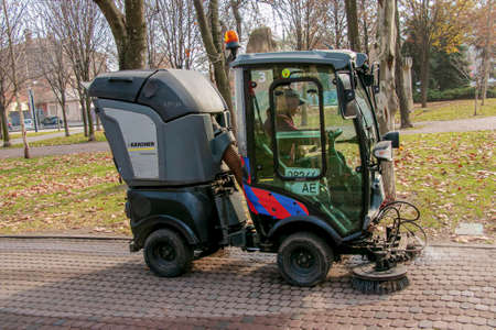 Dnepropetrovsk, Ukraine - 11.22.2021: Municipal service carries out seasonal works in the park. The brushes sweep the asphalt.のeditorial素材