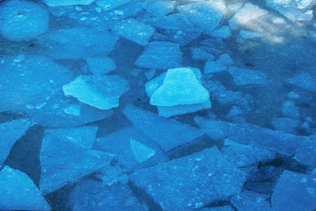 Winter nature background with blocks of ice on frozen water in spring. Abstract background of drifting ice on water.の写真素材
