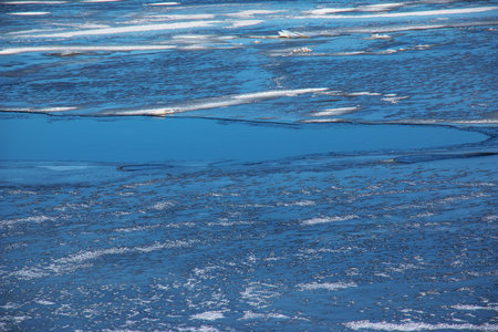 Winter nature background with blocks of ice on frozen water in spring. Abstract background of drifting ice on water.の写真素材