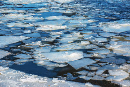 Winter nature background with blocks of ice on frozen water in spring. Abstract background of drifting ice on water.の写真素材