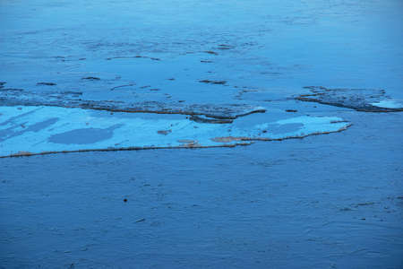 Winter nature background with blocks of ice on frozen water in spring. Abstract background of drifting ice on water.の写真素材