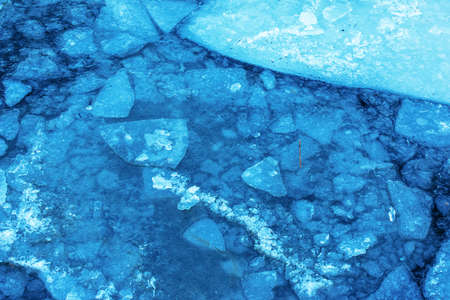 Winter nature background with blocks of ice on frozen water in spring. Abstract background of drifting ice on water.の写真素材