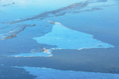Winter nature background with blocks of ice on frozen water in spring. Abstract background of drifting ice on water.の写真素材