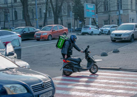 Dnepropetrovsk, Ukraine - 11.22.2021: Accident of two passenger cars due to wrong actions of a food delivery man on a moped.のeditorial素材