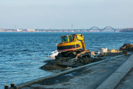 Dnepropetrovsk, Ukraine - 11.26.2021: Excavator works to strengthen the embankment. Hydraulic...