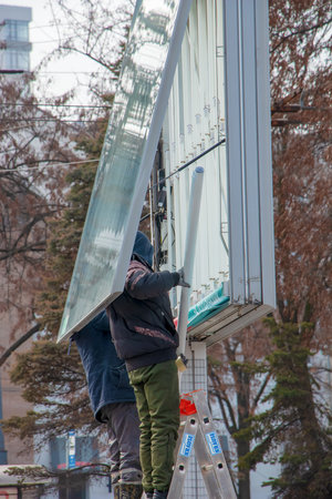 Dnepropetrovsk, Ukraine - 02.09.2022: Installation of outdoor advertising in the city. Specialists climb the stairs to the billboard. risky job. Work at height.のeditorial素材