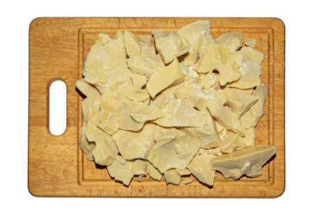 Pieces of cocoa butter on a wooden board. Cocoa butter is an ingredient for making chocolate. Chunks of cocoa butter before grinding. isolate.の写真素材