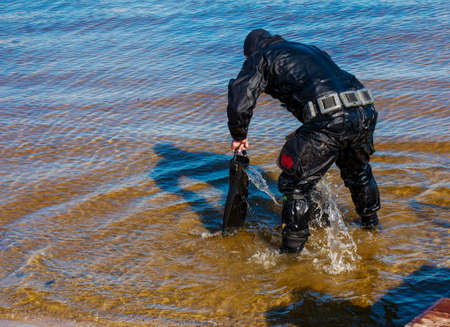Professional diver near the river coastline. commercial diving. Winter.