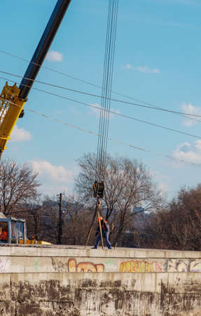 Construction of a bypass road in the industrial area. Builder worker takes the load with concrete...