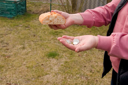 Last money for bread. Bread in the hand of a middle-aged woman. The concept of the world food crisis...