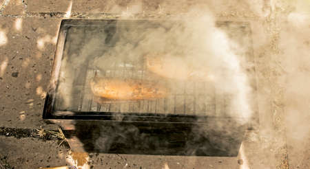 Mackerel fish in a marinade on a grill in a smokehouse. The process of cooking hot smoked mackerel.の写真素材