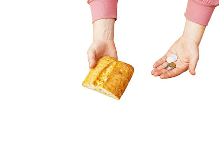 Last money for bread. Bread in the hand of a middle-aged woman. The concept of the world food crisis associated with the war in Ukraine. isolated on white background.の写真素材