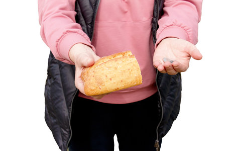 Last money for bread. Bread in the hand of a middle-aged woman. The concept of the world food crisis associated with the war in Ukraine. isolated on white background.の写真素材