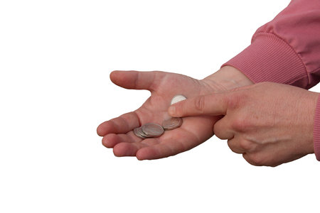 Last money for groceries. Coins in the hand of a middle-aged woman. The concept of the world food crisis associated with the war in Ukraine. isolated on white background.の写真素材