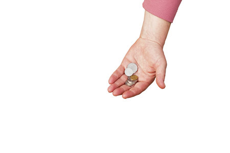 Last money for groceries. Coins in the hand of a middle-aged woman. The concept of the world food crisis associated with the war in Ukraine. isolated on white background.の写真素材