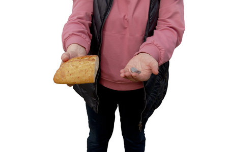 Last money for bread. Bread in the hand of a middle-aged woman. The concept of the world food crisis associated with the war in Ukraine. isolated on white background.の写真素材
