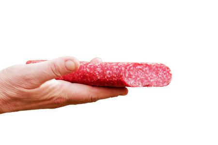 Sausage in the hand of a middle-aged woman. The concept of the world food crisis associated with the war in Ukraine. isolated on white background.の写真素材
