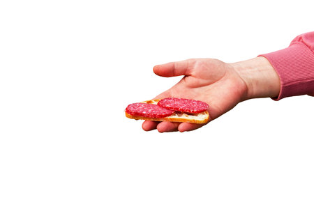 Sandwich with sausage in the hand of a middle-aged woman. The concept of the world food crisis associated with the war in Ukraine. isolated on white background.の写真素材