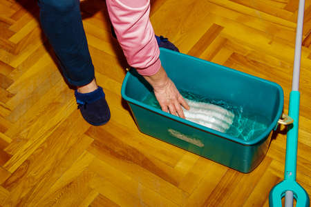 Mop your wood floor. A woman prepares a mop. housekeeping concept.の写真素材