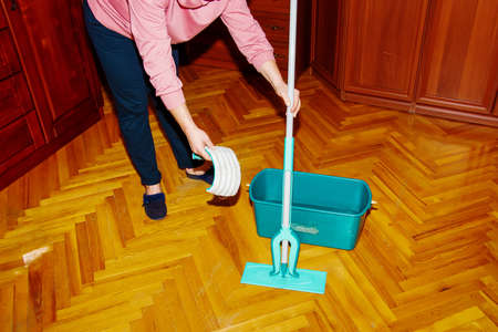 Mop your wood floor. A woman prepares a mop. housekeeping concept.の写真素材