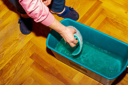 Mop your wood floor. A woman prepares a mop. housekeeping concept.の写真素材