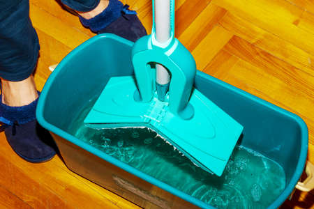 Mop your wood floor. A woman prepares a mop. housekeeping concept.の写真素材