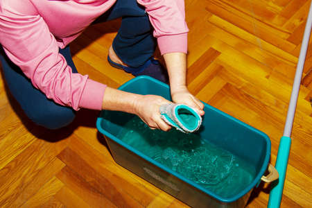 Mop your wood floor. A woman prepares a mop. housekeeping concept.の写真素材