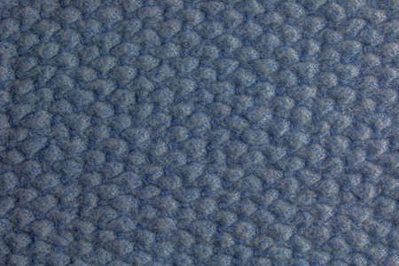 Blue-gray knitted carpet close-up. Textile texture on a gray-blue background. Detailed warm yarn background. Natural wool fabric, sweater fragment.の写真素材