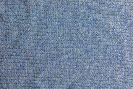 Blue-gray knitted carpet close-up. Textile texture on a gray-blue background. Detailed warm yarn background. Natural wool fabric, sweater fragment.の写真素材