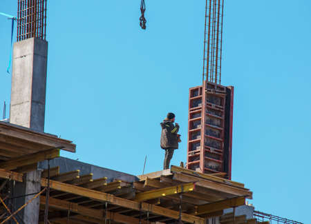Dnepropetrovsk, Ukraine - 02.23.2022: A worker prepares formwork for a modern metal-concrete structure of a residential building.のeditorial素材