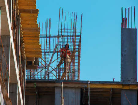 Dnepropetrovsk, Ukraine - 02.23.2022: A worker prepares formwork for a modern metal-concrete structure of a residential building.のeditorial素材