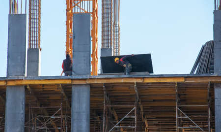 Dnepropetrovsk, Ukraine - 02.23.2022: A worker prepares formwork for a modern metal-concrete structure of a residential building.のeditorial素材
