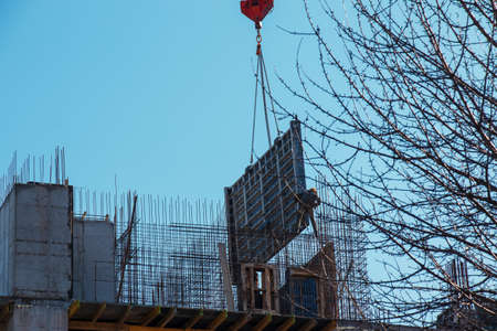 A worker prepares formwork for a modern metal-concrete structure of a residential building.の写真素材