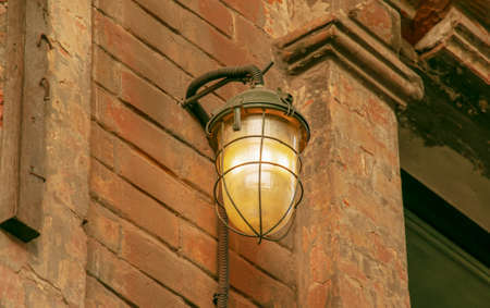 Lamp light on the wall. Antique iron lantern on the wall outside. Garden metal electric lamp. outdoor wall lamp.の写真素材