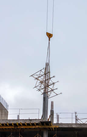 A high-rise construction crane lifts the lattice structure into the zone of building floor formation.の写真素材