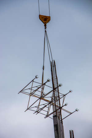A high-rise construction crane lifts the lattice structure into the zone of building floor formation.の写真素材