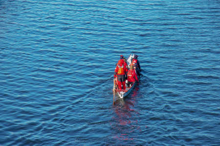 Dnipro, Ukraine - 02.13.2022: Men's rowing team on the blue water. winter training.