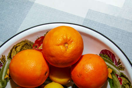 Bright orange oranges in a bowl on a gray table.の写真素材
