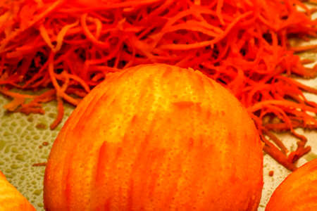 The process of preparing an alcoholic drink orancello at home. Juicy fresh orange peel of yellow-orange color against the background of an orange without peel.の写真素材