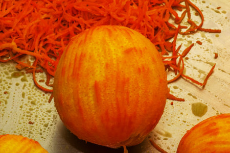 The process of preparing an alcoholic drink orancello at home. Juicy fresh orange peel of yellow-orange color against the background of an orange without peel.の写真素材