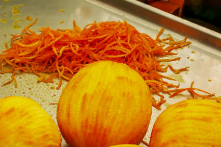 The process of preparing an alcoholic drink orancello at home. Juicy fresh orange peel of yellow-orange color against the background of an orange without peel.の写真素材