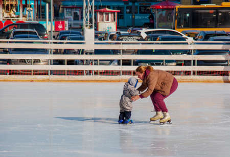 Dnipro, Ukraine - 09.02.2022: People have fun skating on a public ice rink built by the municipality...