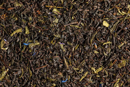 A blend of Ceylon black and green teas. Background of leaf tea with cornflower and calendula petals. view from above.の写真素材