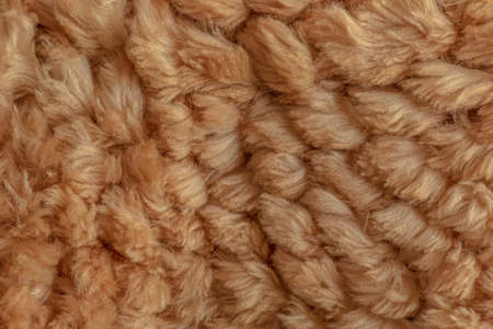 Short smooth beige llama fur texture in the form of a knitted product. close-upの写真素材