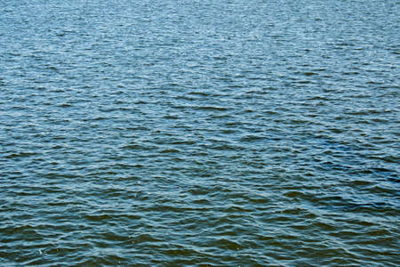 Calm water surface with small ripples. Background of the water surface of the river on a sunny day.の写真素材