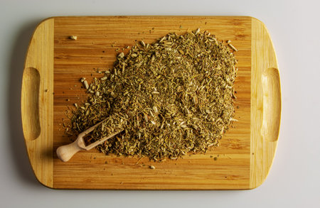 Dry yerba mate leaves, traditional drink of Argentina, on a wooden board and a wooden spoon...