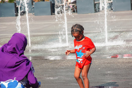 Vienna, Austria - 06.13.2022: Children frolic in the jets of the city fountain in the summer heatのeditorial素材